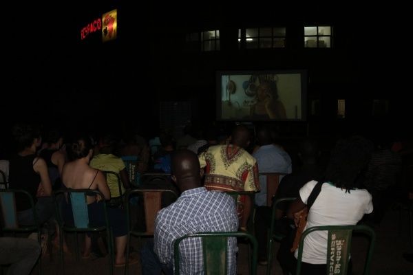 quelques membres sympathisants posant devant l'affiche, et le public en pleine projection